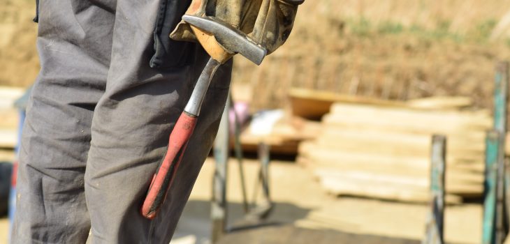 Hantverkare med verktygsbälte. Försäkring mot byggfel - hur fungerar det?